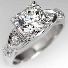 a diamond ring with three stones on the sides and an intricate band around the band