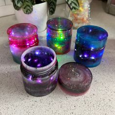 several different colored glass jars sitting on a counter