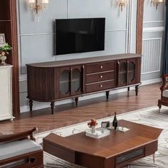 a living room filled with furniture and a flat screen tv on top of a wooden entertainment center