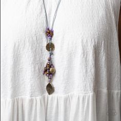 An Earthy Assortment Of Purple And Plum Seed Beads, Rustic Brass Discs, And Wooden Accents Glide Along Lengthy Strands Of Gray Cording That Knot Around A Hammered Brass Disc. Tassels Of Matching Beads, A White Shell-Like Accent, Floral Silver Bead, And Brass Leaf Charm Dance From The Bottom, Adding Playful Movement To The Free-Spirited Display. Features An Adjustable Clasp Closure. Sold As One Individual Necklace. Includes One Pair Of Matching Earrings. Elegant Purple Necklaces For Beach, Elegant Purple Necklace For The Beach, Elegant Purple Necklace For Beach, Adjustable Purple Beaded Necklace With Dangling Beads, Adjustable Long Purple Beaded Necklace, Purple Bohemian Jewelry For Summer, Adjustable Purple Necklaces With Dangling Beads, Adjustable Purple Necklace With Dangling Beads, Bohemian Purple Beaded Necklace With Dangling Beads