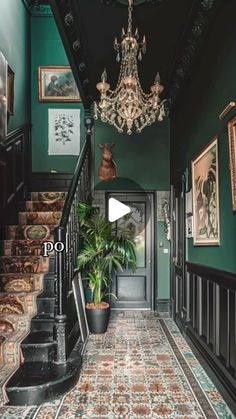 an ornate hallway with green walls and carpeted stairs leading up to the second floor