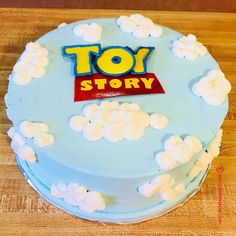 a toy story cake on a wooden table with white frosting and blue icing