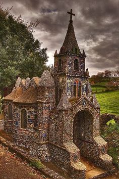 an old church made out of rocks with a cross on it's steeple