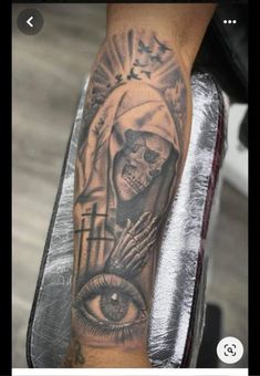 a person with a tattoo on their arm that has an image of a skull and cross