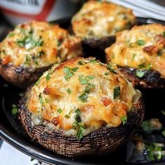 baked stuffed mushrooms with cheese and herbs on a black plate, ready to be eaten