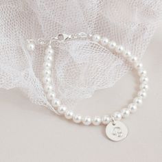 "* Flower Girl Pearl and Sterling Silver Initial Disc Bracelet *     * Perfect for the Flower Girls *  * Beautiful white crystal pearl bracelet with a soft brushed finish sterling silver 9mm initial disc complimented with a sterling silver clasp and 1/2\" extender chain.  * This listing is for 1 flower girl bracelet. * Other flower girl jewelry from J Jensen Weddings:  * White Pearl Flower Bracelet:  https://www.etsy.com/listing/519679918/flower-girl-bracelet-brides-gift-flower * Rose Gold Pearl Personalized Pearl Bracelet, Elegant White Bracelets, White Dainty Pearl Bracelet For Birthday, Dainty White Pearl Bracelet For Birthday, Flower Girl Jewelry, Flower Girl Bracelets, Girl Bracelet, Disc Bracelet, Cross Gift