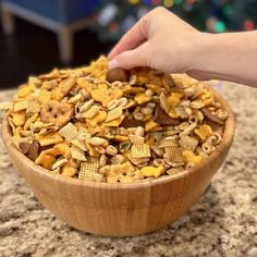 a wooden bowl filled with cheetos sitting on top of a counter next to a christmas tree