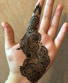 the hand is decorated with henna designs on it, and has an intricate pattern