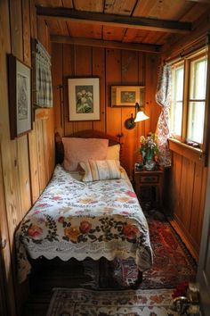 a bed sitting in a bedroom next to a wooden wall with pictures hanging on it