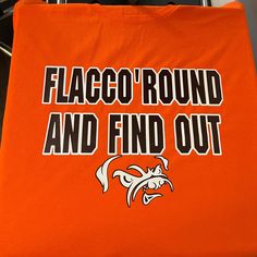 Flacc O Round and Found Out Tees are pressed and ready for your next football Tailgate Party or Sunday Funday. This unisex tee is going to be a favorite at all the Dawg Pound gatherings!  * Unisex, order size accordingly  * soft-Style airlume jersey * This product features an original Kels Creative Hive design, and is not endorsed or licensed in any way by any team, league or organization . For best wear wash garment inside and in cold water, tumble dry on low heat Graphic Print T-shirt For Football Season Fan Events, Game Day Football Season T-shirt With Logo, Football Season Fan Gear T-shirt With Logo, Orange Short Sleeve T-shirt For Game Day, Football Season Fan Apparel T-shirt With Logo, Football Season Fan Merchandise T-shirt With Logo Print, Football Season Fan Apparel T-shirt With Heat Transfer Vinyl, Football Fan T-shirt With Heat Transfer Vinyl, Fan Apparel T-shirt For Team Events With Letter Print