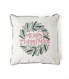 a white pillow with a merry christmas wreath on it