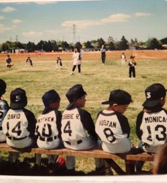 a group of young boys sitting on top of a wooden bench