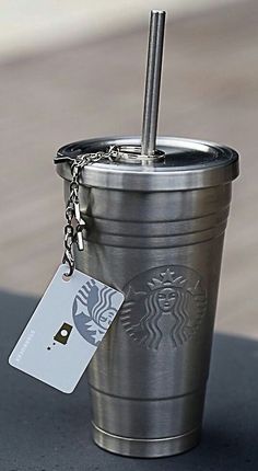 a starbucks cup with a keychain attached to it sitting on top of a table