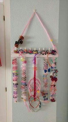 a wall hanging made out of bracelets and other items on a white door frame