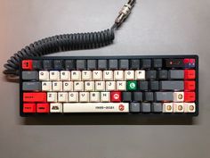 a computer keyboard sitting on top of a table next to a corded phone plugged into it