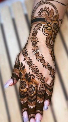 a woman's hand with henna tattoos on it