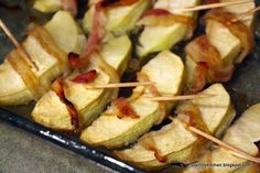 several skewered potatoes with bacon and toothpicks sticking out of the top