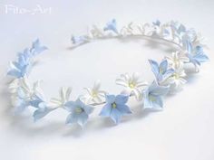 a white and blue flower headband with flowers on the side, sitting in front of a white background