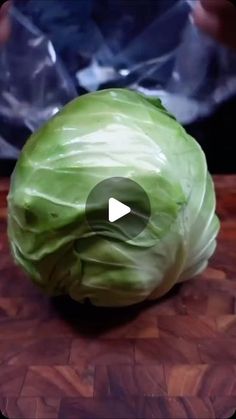 a head of cabbage sitting on top of a wooden table