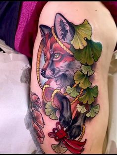 a woman's thigh with a tattoo of a fox and leaves on the side