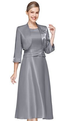 Introducing the Nina Nischelle 3623-GRY Jacket Dress, a true embodiment of sophistication and timeless style. This ensemble is meticulously crafted to create an air of elegance for any upscale event. The knee-length dress speaks to the essence of classic femininity, making it a perfect choice for weddings, corporate gatherings, or formal celebrations. The luxurious, shimmering grey fabric of the dress is carefully selected for its quality and luster, ensuring that you sparkle with understated elegance. A highlight of this dress is the three-quarter sleeve jacket that elegantly drapes over the shoulders. It is adorned with an exquisite brooch that adds a focal point of glamour to the overall attire, capturing the attention of onlookers without the need for additional accessories. Attention Elegant Tailored A-line Outerwear, Elegant A-line Formal Outerwear, Elegant A-line Outerwear For Party, Elegant A-line Evening Dress For Winter, Elegant A-line Mother Of The Bride Dress, Elegant A-line Mother Of The Bride Dress For Banquet, Elegant Fitted Evening Dress For Winter, Satin Long Sleeve Dresses For Mother Of The Bride, Formal A-line Satin Mother Of The Bride Dress