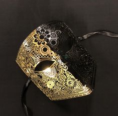 This men's masquerade mask is hand painted half gold and half black. Mask also has a unique design and is made of a lightweight laser cut metal. This luxury mask is great for masquerade or costume party! Mask Comes with black silk ribbon ties attached. Masquerade Ball Men, Black And Gold Masquerade Mask, Gold Masquerade Mask, Black Masquerade Mask, Mask Venetian, Luxury Mask, Mens Masquerade Mask, Black And Gold Aesthetic, Mask Ideas