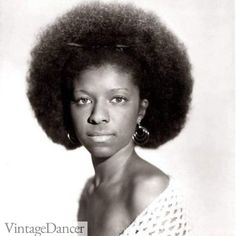 an old photo of a woman with large afros and big earrings on her head