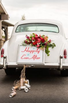 an old white car is decorated with flowers and ribbons for the wedding day, as well as a sign that says happily ever after