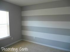 an empty room with gray and white striped walls