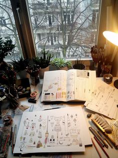 an open book sitting on top of a desk next to a lamp and other items