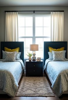 two beds in a bedroom with yellow and blue bedding