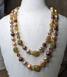 "Beautiful glass bead double strand necklace.  Very pretty glass beads emulating agate, faux coloured pearls and faceted beads with an Aurora Borealis coating in a champagne colour.  Gold tone bead caps add detail to this beauty.  The closure is a snap lock with its own large glass bead detail.  The necklace strands are 14\" inches and 18 inches long.Please check out my shop for all kinds of gift ideas. Vintage and Contemporary options: https://mrmugginsmarket.etsy.com" Champagne Colour, Snap Lock, Double Strand Necklace, Ideas Vintage, Faux Pearl Necklace, Champagne Color, Glass Bead Necklace, Pearl Color, Bead Caps