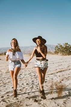 two girls walking on the beach holding hands and wearing cowboy hats, with text that reads melhores fotos no desero