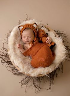 a newborn baby is sleeping in a basket with two stuffed animals on it's side