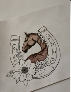 a drawing of a horse in a horseshoe with flowers on the side and a flower inside