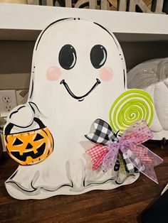 a wooden sign with a ghost holding a lollipop