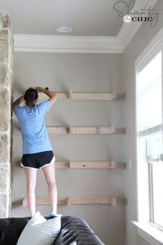 a woman climbing up the side of a stone wall