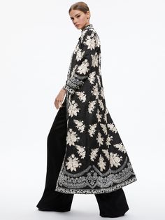 Thomas Embroidered Maxi Coat In Black/silver Spring Silk Outerwear With Resham Embroidery, Elegant Long Abaya With Resham Embroidery, Elegant Floral Embroidered Winter Outerwear, Elegant Winter Outerwear With Floral Embroidery, Elegant Long Sleeve Abaya With Intricate Embroidery, Fitted Outerwear With Intricate Embroidery, Elegant Long Embroidered Outerwear, Bohemian Evening Outerwear With Long Sleeves, Luxury Spring Outerwear With Floral Embroidery