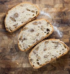 three pieces of bread sitting on top of a wooden cutting board