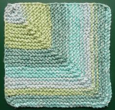 a crocheted dishcloth is shown on a green surface with white and blue stripes