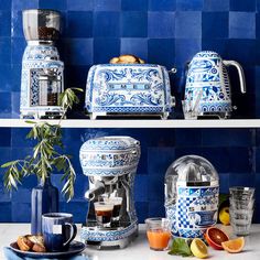 blue and white kitchen decor with coffee maker, juicer, oranges and other items