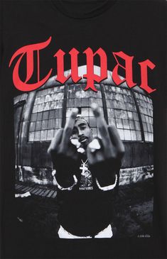 a black t - shirt with the word tupac on it and a man holding his hands up in front of him