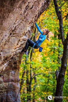 a woman climbing up the side of a cliff