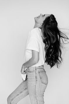 black and white photograph of woman with long hair in mid - air, looking up