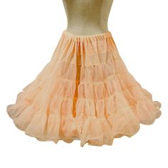 Vintage square dance petticoat from the 70s. This pale peach crinoline is knee-length and has 2 layers of crisp nylon with ruffled trim. There's quite a bit of fabric here for lots of volume and the waist is elasticized.  Condition is good overall with the only notable issue being the waistband has a 1" open gap which shows the elastic within.  Size Medium - Sam's brand - Made in USA - Nylon 26" to 34" (laid flat to max comfort stretch) - 22" length (approx) For more vintage clothing, please vis Vintage Crinoline Petticoat For Spring, Spring Vintage Crinoline Petticoat, Summer Vintage Crinoline Petticoat, Fitted Retro Petticoat With Attached Cancan, Vintage Petticoat With Attached Cancan For Summer, Fitted Retro Petticoat With Cancan, Retro Fitted Petticoat With Attached Cancan, Retro Fitted Petticoat With Cancan, Dance Petticoat With Ruffles And Stretch