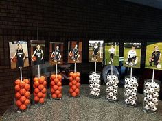 soccer balls and pictures are on sticks in front of the wall