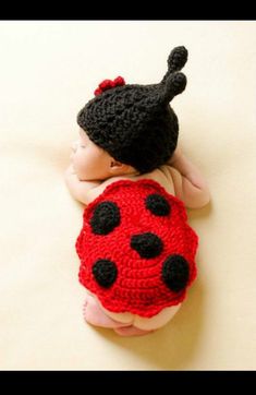 a crocheted ladybug hat on top of a sleeping baby