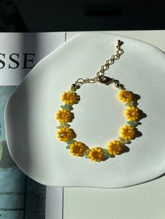 Brighten up your day with our stunning Handcrafted Sunflower Beaded Bracelet, a delightful piece inspired by the vibrant beauty of sunflowers. Each bracelet is meticulously crafted to bring a touch of sunshine to your jewelry collection.  Bracelet Info  Size: 1cm (Width, sunflower size) x 15cm (Length) with a 5cm extension chain  Total size: 20cm (including extension chain) Finding Material: Gold-plated brass Beads: Miyuki seed beads, glass rondelle beads The fish line may be visible as it is a handmade product.  Jewelry Care  To ensure your gold-plated earrings remain beautiful and last longer, please follow these jewelry care instructions: Avoid Moisture: Keep your earrings dry. Remove them before swimming, showering, or exercising to prevent damage from water and sweat. Store Properly: Sunflower Beaded Bracelet, Beaded Flower Bracelet, Bracelet Aesthetic, Sunflower Bracelet, Diy Jewelry Set, Bracelet Summer, Aesthetic Flower, Floral Bracelet, Brass Beads