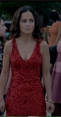 a woman in a red dress walking down the street