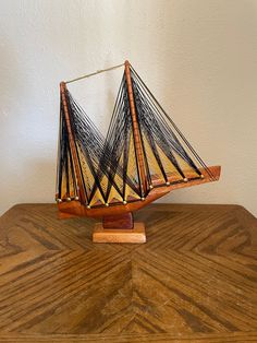 a wooden model boat sitting on top of a table